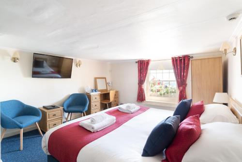 a hotel room with two beds and a television at The Kings Head in Deal