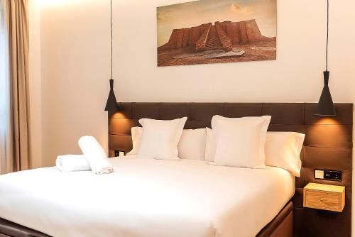 a bedroom with a bed with white sheets and pillows at Woohoo Rooms Boutique Luna in Madrid