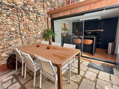 a wooden table and chairs in a room with a stone wall at Barri Antic Cambrils in Cambrils