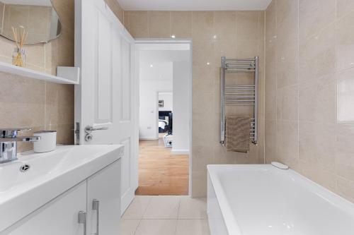 a white bathroom with a sink and a tub at Apartment in Hertfordshire in Hemel Hempstead