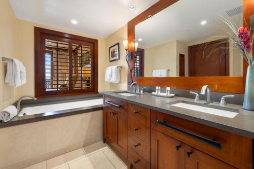 a bathroom with two sinks and a large mirror at Ko Olina Beach Villas B410 in Kapolei
