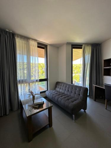 a living room with a couch and a coffee table at Grey escape apartments in Qalḩāt