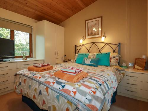a bedroom with a large bed with blue pillows at 4 The Glade in Wadebridge
