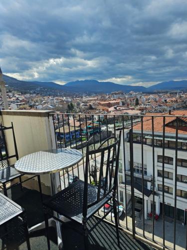 una mesa y sillas en la parte superior de un balcón en Skyland Apartment Prizren, en Prizren