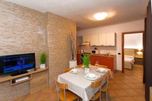 a dining room with a table and a kitchen at Residence Delle Rose in Tremosine Sul Garda