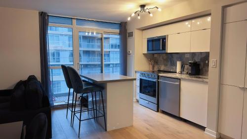 a kitchen with a counter and a table and chairs at Downtown 2 bedroom Gem with Free Parking in Toronto