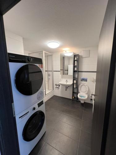 uma pequena casa de banho com máquina de lavar e secar roupa em City Unterkunft 4 em Heilbronn