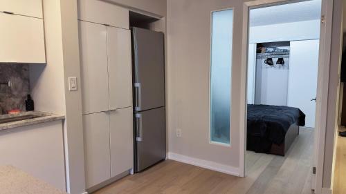 a kitchen with a refrigerator and a bedroom at Downtown 2 bedroom Gem with Free Parking in Toronto
