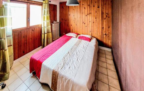 ein Schlafzimmer mit einem Bett in einem Zimmer mit Holzwänden in der Unterkunft 1 Bedroom Stunning Home In Juvisy-sur-orge in Juvisy-sur-Orge