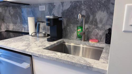 a kitchen counter with a sink and a coffee maker at Downtown 2 bedroom Gem with Free Parking in Toronto