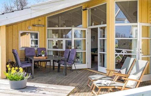 a screened in porch with a table and chairs at Holiday Home Sydals 57 With Hot Tub in Skovby
