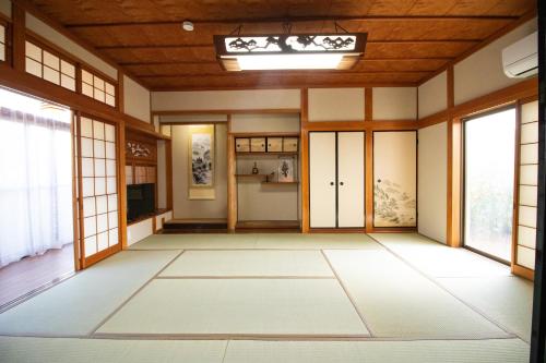 an empty room with doors and windows at Kanwa Heart House KIX in Kaizuka