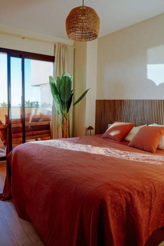 a bedroom with a large bed with a red blanket at Casa del Sol: Sunrise to Sunset in Sitio de Calahonda