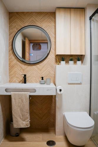 a bathroom with a toilet and a mirror at Casa del Sol: Sunrise to Sunset in Sitio de Calahonda