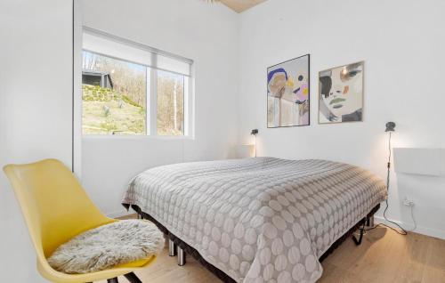 a bedroom with a bed and a yellow chair at Beautiful Home In Knebel With House Sea View in Knebel