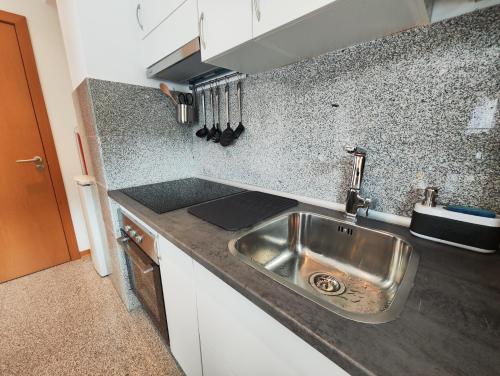 uma cozinha com um lavatório e uma bancada em Apartamento al lado de la playa em Baiona