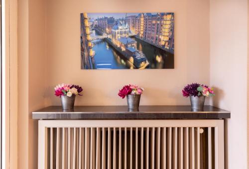 a radiator in a room with flowers in buckets at Hotel Continental Hamburg Hauptbahnhof in Hamburg