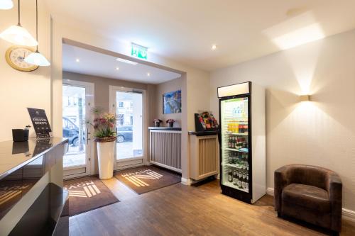 a room with a refrigerator and a chair in a store at Hotel Continental Hamburg Hauptbahnhof in Hamburg