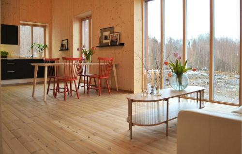 a living room with a table and red chairs at 3 Bedroom Beautiful Home In Katrineholm in Katrineholm