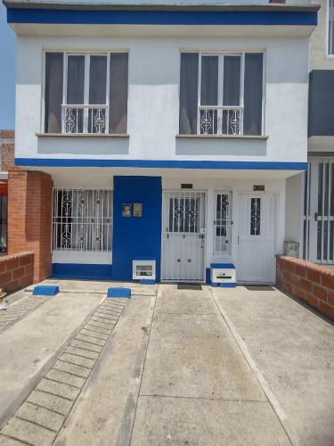 a white and blue house with doors and windows at Linda y acogedora casa in Pereira