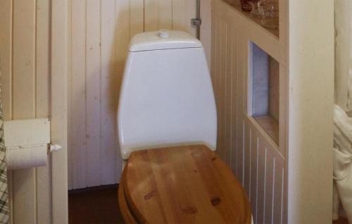 a toilet with a wooden seat in a bathroom at 1 Bedroom Amazing Home In Leksand in Leksand
