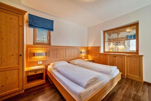 um quarto com uma cama grande e 2 janelas em Obermoarhof Mutspitze 1 em Lagundo