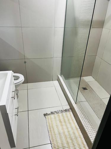 een badkamer met een douche en een toilet bij Wild olive Self catering in Windhoek