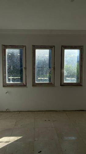 an empty room with three windows in an empty room at Hukukçular Sitesinde in Buyukcekmece