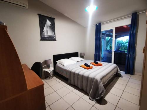 een slaapkamer met een bed met 2 oranje badjassen erop bij Villa Perroquet - vue mer - grande piscine chauffée in La Possession