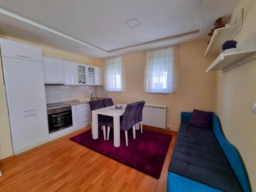 a kitchen and living room with a table and a couch at VIP Bogić in Zlatibor