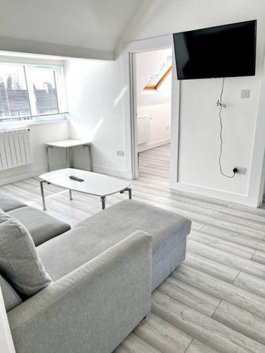 uma sala de estar com um sofá e uma televisão de ecrã plano em Luton flat with parking em Luton