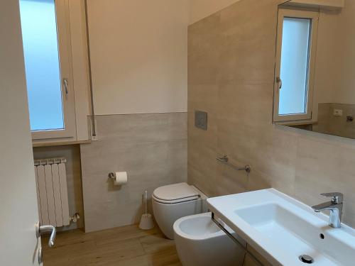 a bathroom with a white toilet and a sink at Casa Eva in Bibione