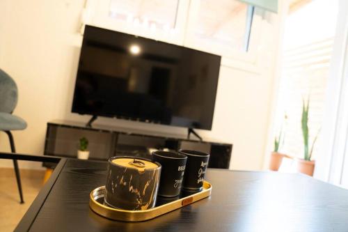 three coffee mugs on a tray on a table at Areston hersonisos apartment in Hersonissos
