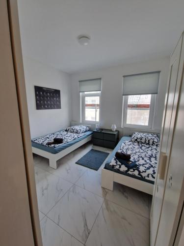 two beds in a room with two windows at Apartment SweetDreams in Bremerhaven