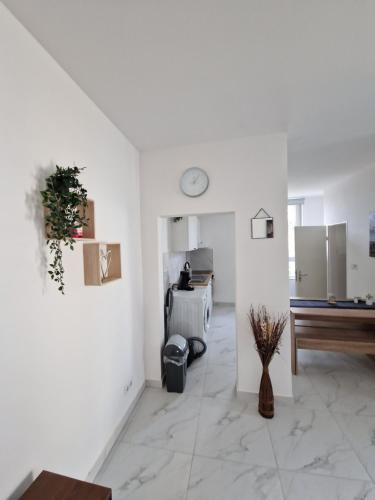 ein Wohnzimmer mit weißen Wänden und einer Uhr an der Wand in der Unterkunft Apartment SweetDreams in Bremerhaven