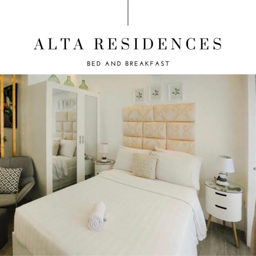 a bedroom with a large white bed with a white headboard at Alta Residences in Daraga