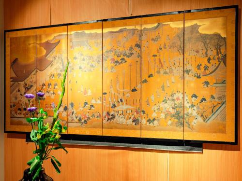 a large painting on a wall with a vase of flowers at 【BRITZ千種】貸切コンドミニアムホテル /千種駅徒歩３分 in Chikusachō