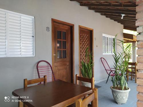 ein Esszimmer mit einem Tisch, Stühlen und einer Tür in der Unterkunft Pousada irmãos Oliveira in Lindóia