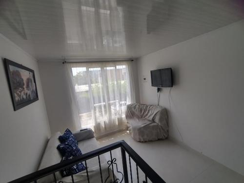 sala de estar con sofá y ventana en Linda y acogedora casa en Pereira