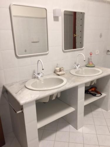 a bathroom with two sinks and a mirror at Foresto Case Vacanza in Volta Mantovana