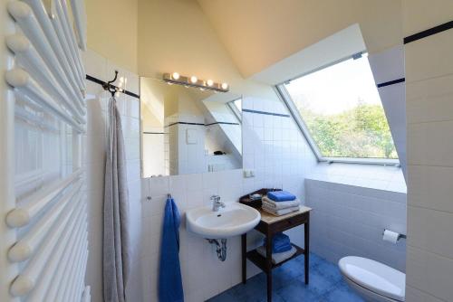 uma casa de banho com um lavatório, um WC e uma janela. em Ferienwohnung 8 - b57447 em Neuenkirchen