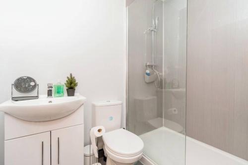 a white bathroom with a toilet and a shower at Bradford Centre - Secret Corner in Bradford