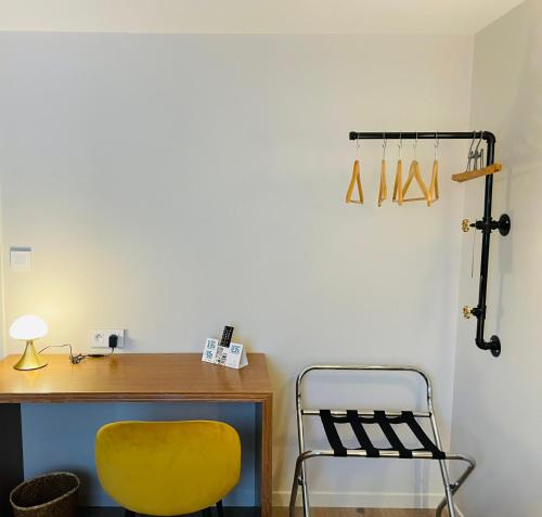 a yellow chair next to a desk with a yellow chair at Restaurant Hotel Logis Chez Sophie in Briouze