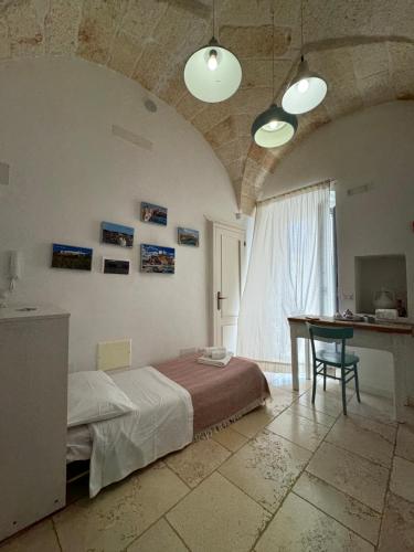 a bedroom with a bed and a table in a room at Casa Mida - Guest House in Pezze di Greco