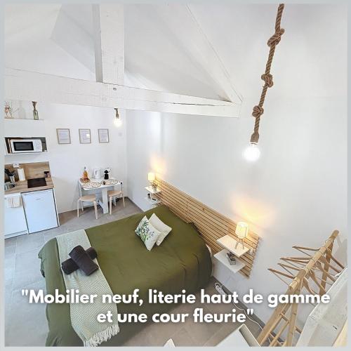 a living room with a bed and a table at Le Jardin des Plantes Rouen Studios et F2 au calmes, Terrasse, stationnement gratuit in Rouen
