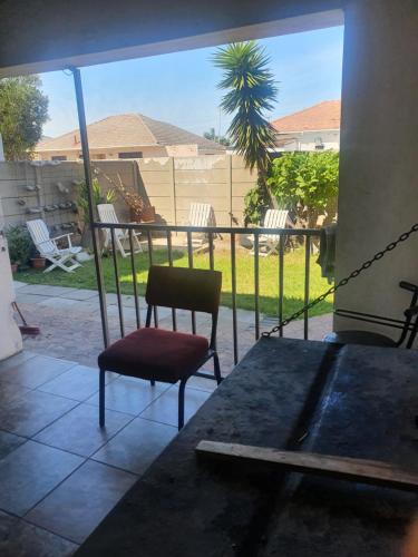 um quarto com uma cadeira e uma mesa em Ludinz guest house na Cidade do Cabo