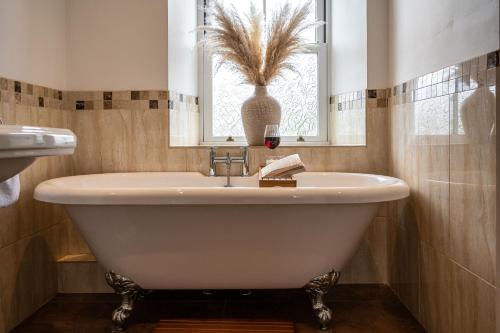 a white bath tub in a bathroom with a window at Fairfield House in Newsham