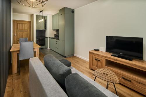 a living room with a couch and a flat screen tv at Symphony City Square Aparthotel in Wrocław