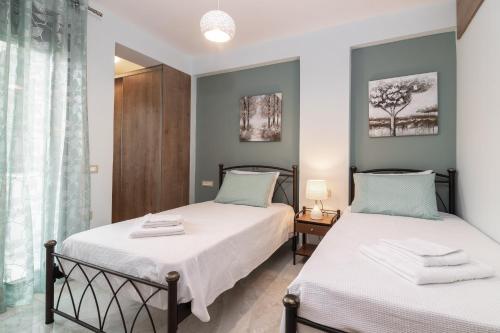 a bedroom with two beds and a window at Al Centro Zante city flat in Zakynthos