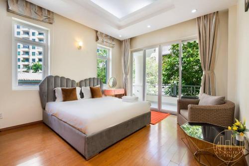 um quarto com uma cama, uma cadeira e janelas em KN3 Holiday Villa em Ho Chi Minh